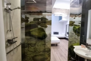 Fotografía del baño de la habitación familiar con dos camas dobles y una individual